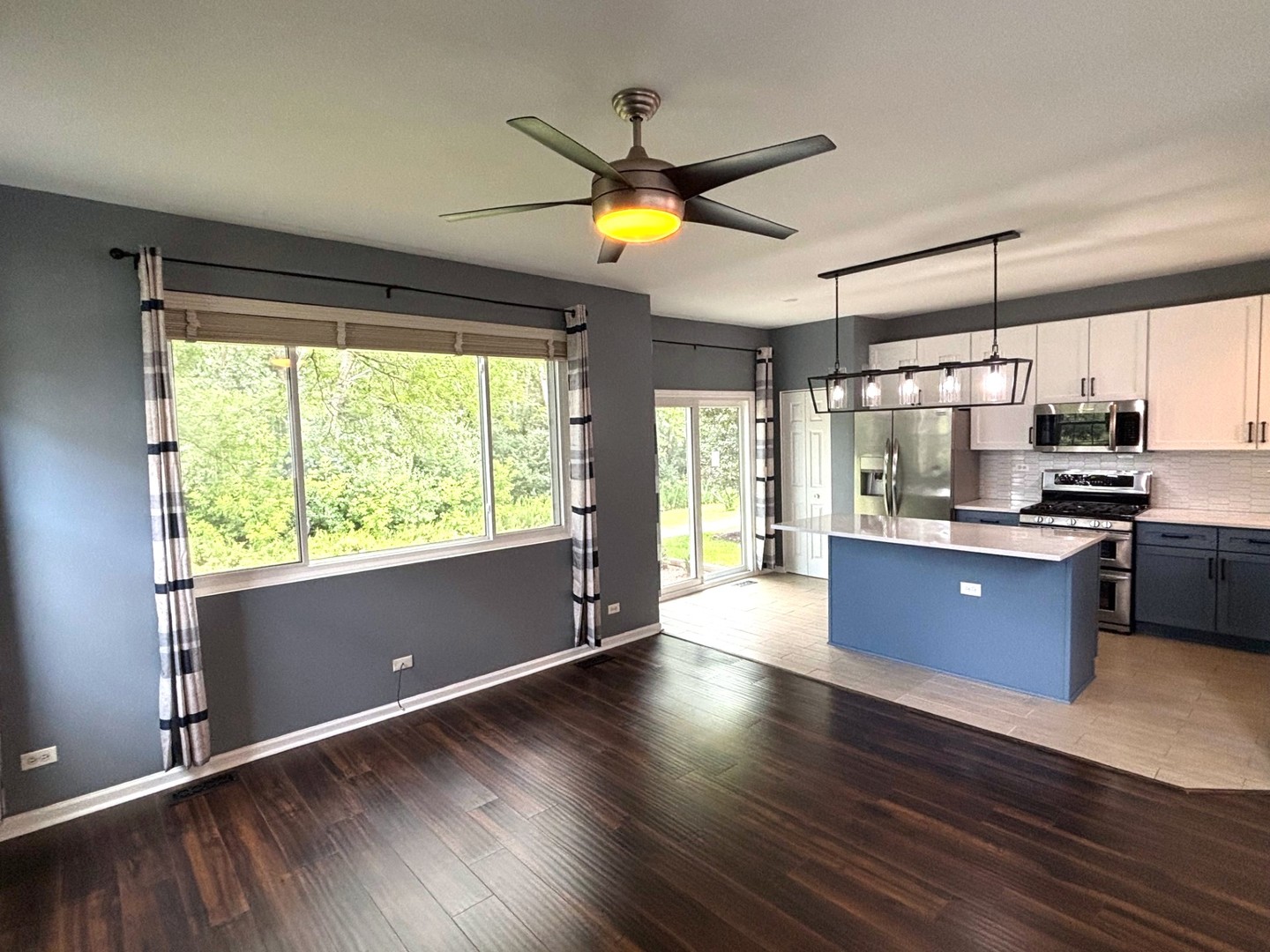 2468 Reflections Drive Aurora, IL 60502 - Photo 8 of 44 a kitchen with stainless steel appliances granite countertop a stove a refrigerator a sink a dining table and chairs with wooden floor