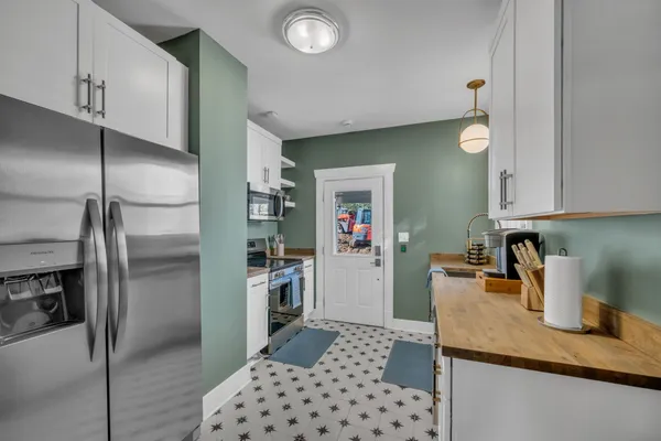 a kitchen with stainless steel appliances granite countertop a refrigerator and a sink