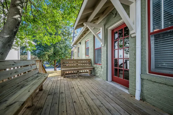 a view of a house with wooden deck and furniture