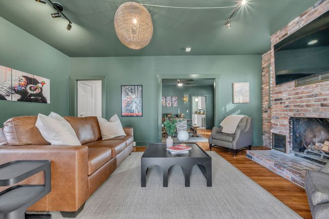 a living room with furniture a flat screen tv and a fireplace