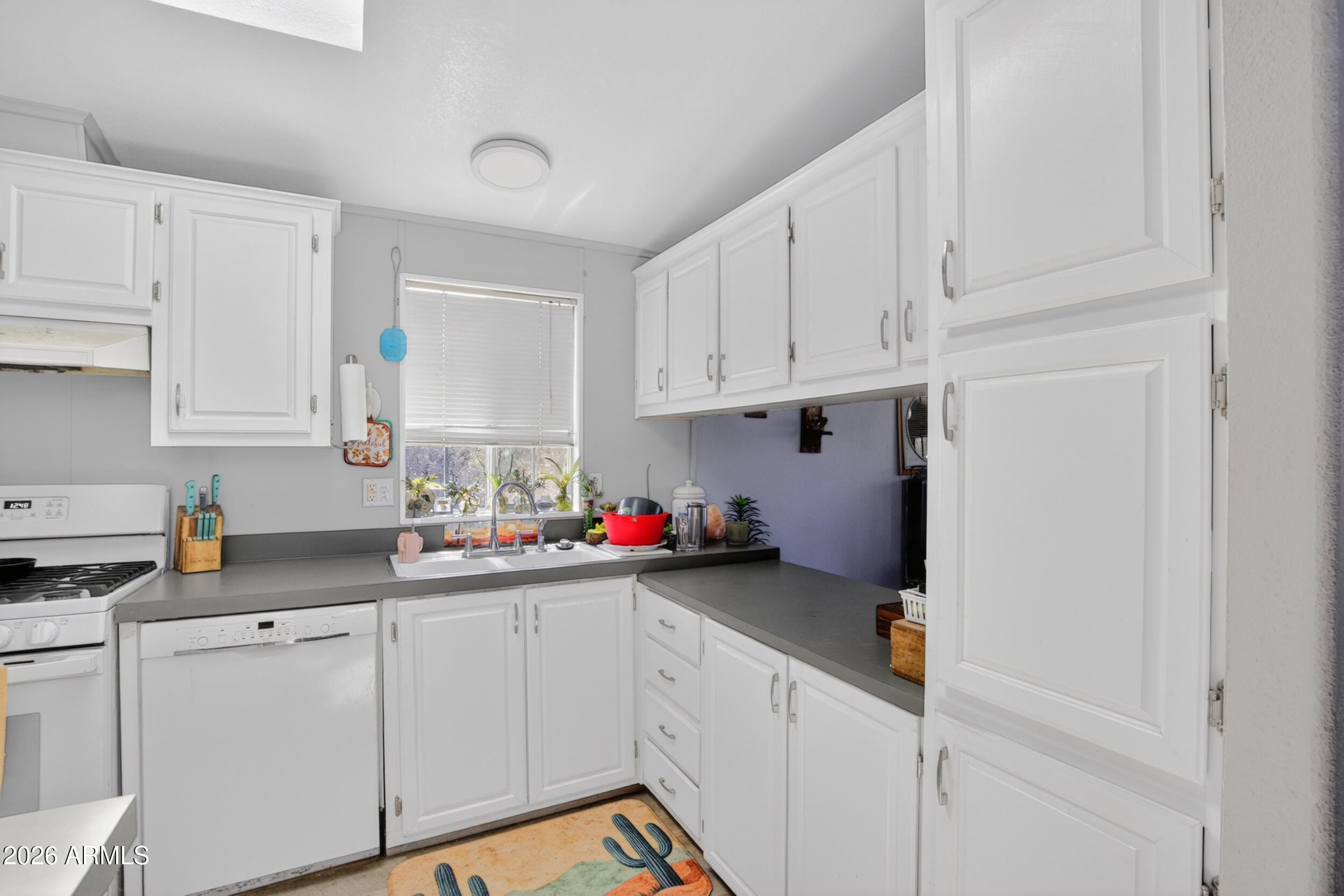 38809 East Spotted Horse Road Florence, AZ 85132 - Photo 3 of 40 a kitchen with white cabinets and white appliances