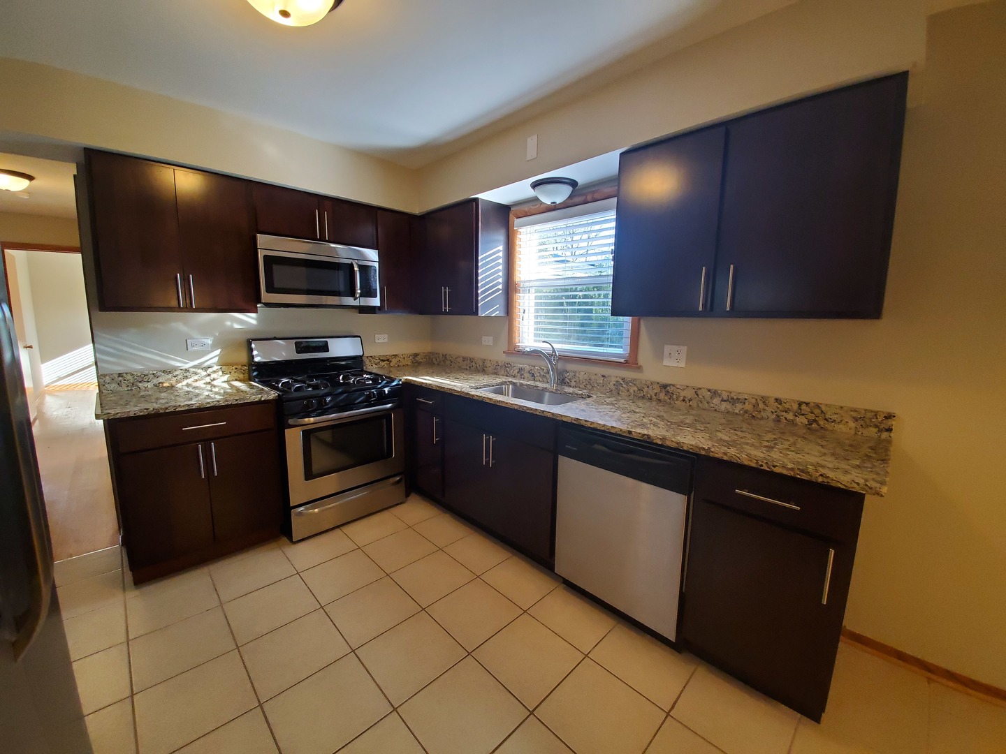 8307 Ballard Road Niles, IL 60714 - Photo 12 of 22 a kitchen with stainless steel appliances granite countertop a stove a sink and a microwave