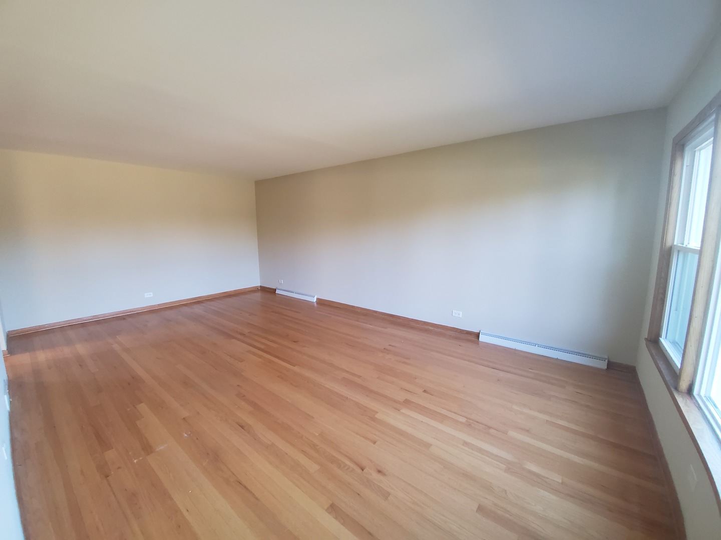 8307 Ballard Road Niles, IL 60714 - Photo 3 of 22 an empty room with wooden floor and windows