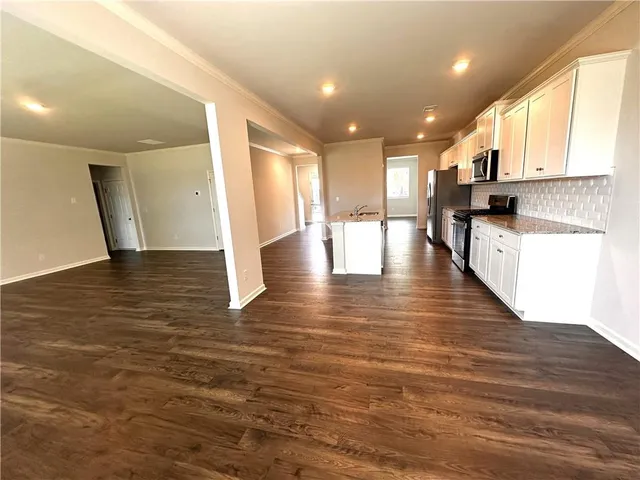 a view of a kitchen with kitchen island a stove a wooden floor and a window