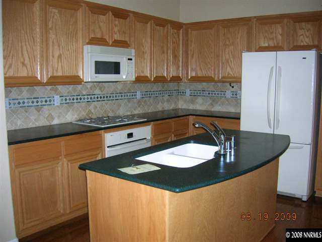 1810 Granite Chief Drive Reno, NV 89521 - Photo 2 of 9 a kitchen with stainless steel appliances granite countertop a sink a stove a microwave and refrigerator