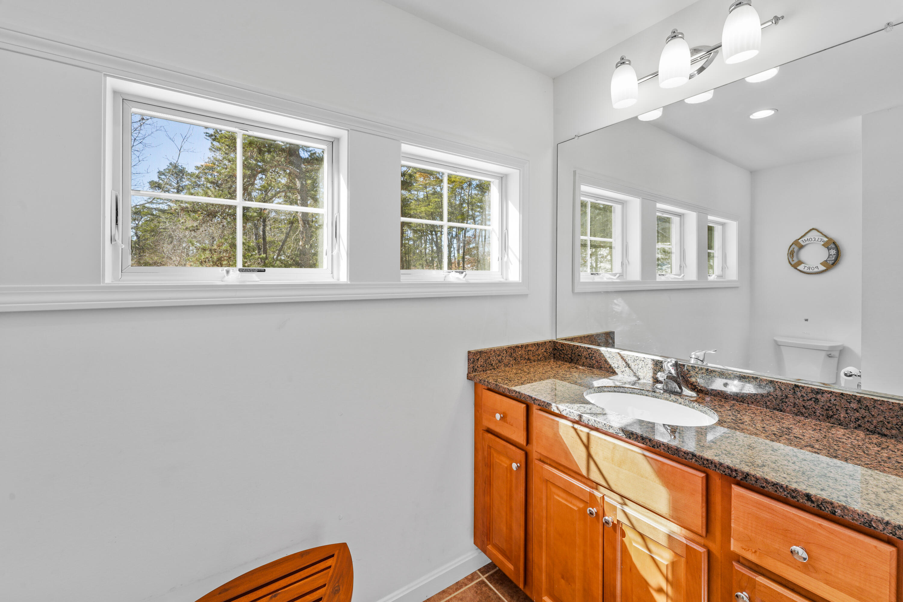 45 Perch Pond Way Wellfleet, MA 02667 - Photo 64 of 82 a bathroom with a granite countertop sink a large mirror and a window