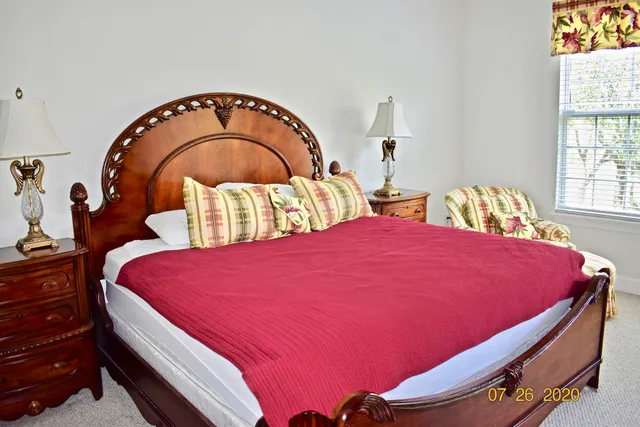 a large bed sitting in a bedroom next to a window