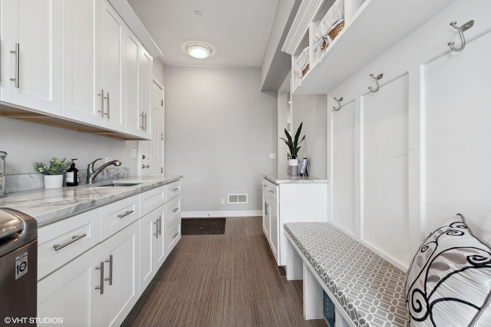 1853 Checker Road Long Grove, IL 60047 - Photo 32 of 63 a kitchen with a sink dishwasher a stove and white cabinets with wooden floor