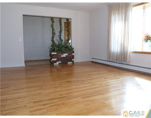 1112 New Dover Road Edison, NJ 08820 - Photo 16 of 25 a view of an empty room with wooden floor and a window
