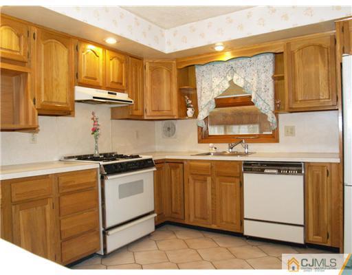 1112 New Dover Road Edison, NJ 08820 - Photo 4 of 25 a kitchen with stainless steel appliances granite countertop a stove a sink and a microwave