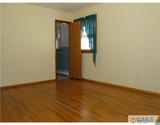 1112 New Dover Road Edison, NJ 08820 - Photo 5 of 25 a view of an empty room with wooden floor and a window