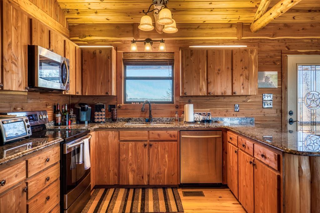3151 Orth Road Olney, TX 76374 - Photo 10 of 37 a kitchen with stainless steel appliances granite countertop a sink and wooden cabinets