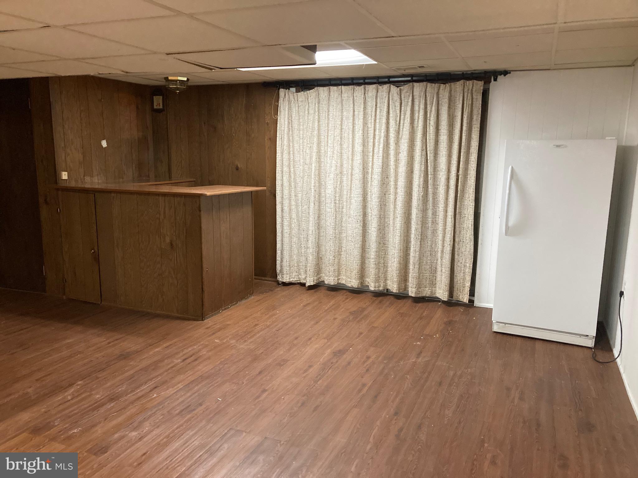 706 Crosby Road Baltimore, MD 21228 - Photo 11 of 41 an empty room with wooden floor and windows