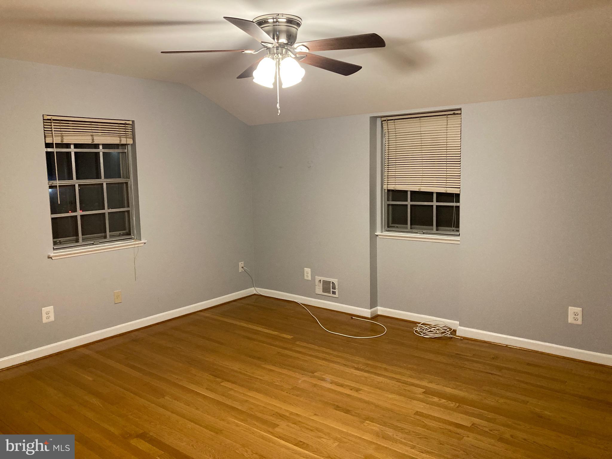 706 Crosby Road Baltimore, MD 21228 - Photo 20 of 41 a view of an empty room with a window and wooden floor