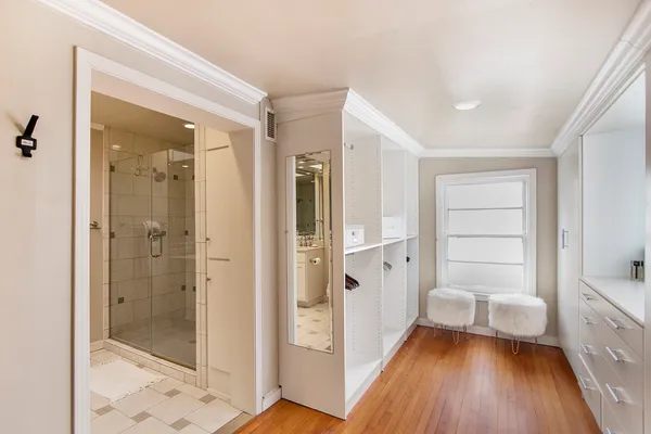 a view of a hallway with bathroom and wooden floor
