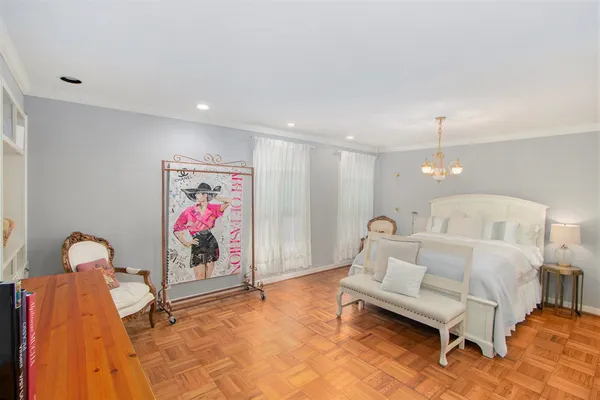 a spacious bedroom with a bed and a chandelier
