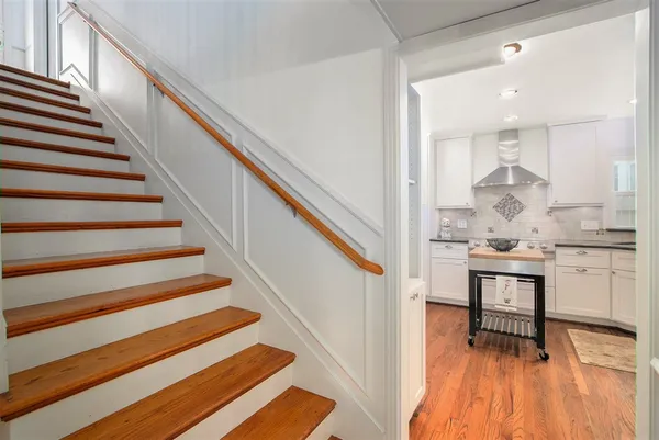 a view of entryway and kitchen with wooden floor