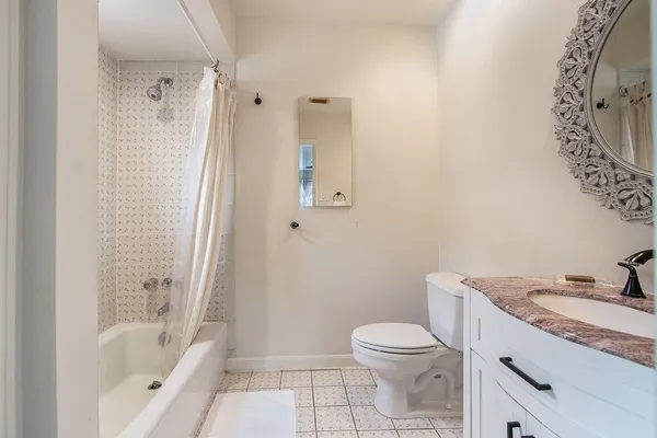a bathroom with a granite countertop sink a toilet and shower