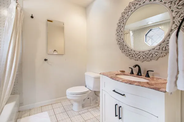 a bathroom with a granite countertop toilet sink and mirror