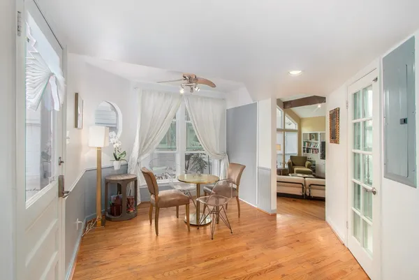 a living room with furniture a large window and wooden floor