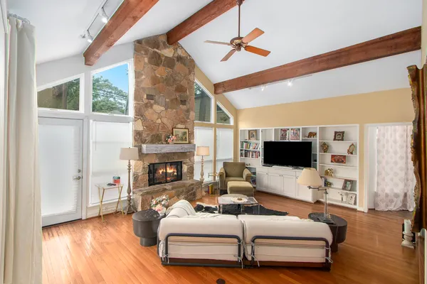 a living room with furniture a fireplace and a flat screen tv