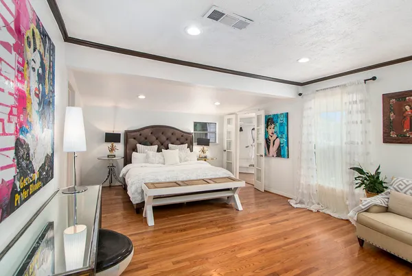 a spacious bedroom with a bed window and couch