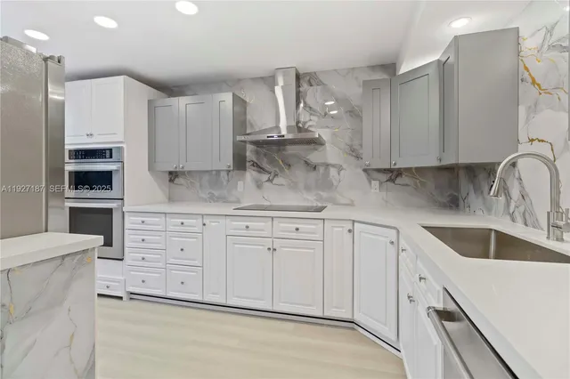a kitchen with cabinets appliances a sink and a counter top space