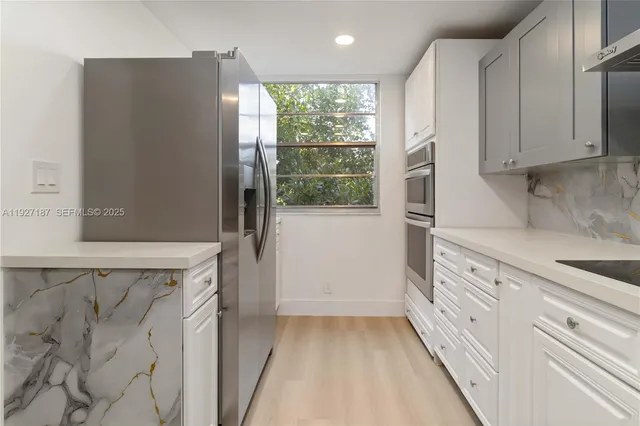 a kitchen with granite countertop white cabinets and white appliances