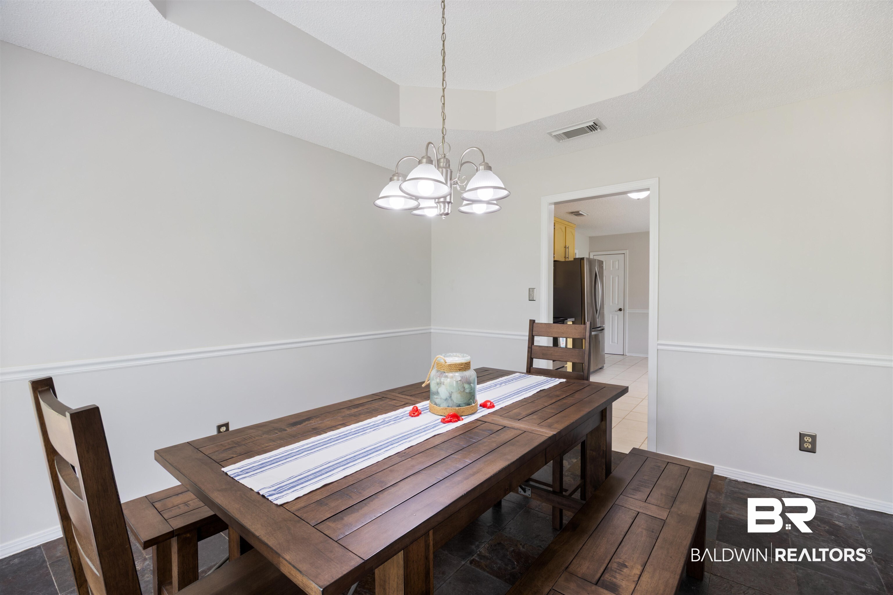 9771 Clarke Ridge Road Foley, AL 36535 - Photo 37 of 72 Dining area with a raised ceiling and notable chandelier.
