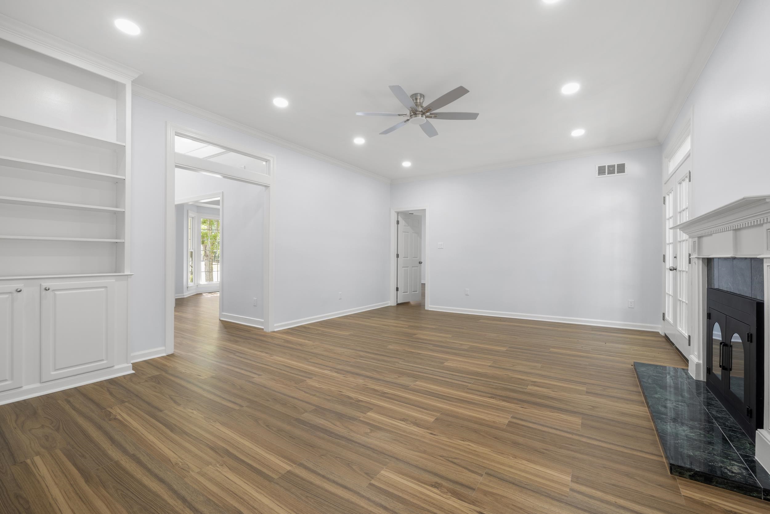 486 Brook Ridge Circle Memphis, TN 38018 - Photo 14 of 40 Unfurnished living room featuring a fireplace, recessed lighting, a ceiling fan, dark wood-style flooring, and crown molding