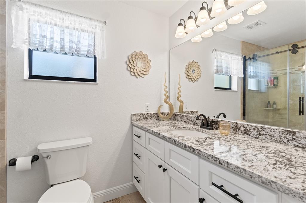 488 Fieldstone Lane Spring Hill, FL 34606 - Photo 27 of 55 a bathroom with a granite countertop sink mirror and toilet