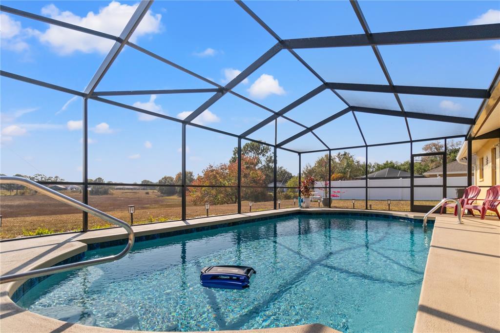 488 Fieldstone Lane Spring Hill, FL 34606 - Photo 37 of 55 a view of a swimming pool with a chair and the floor to ceiling window