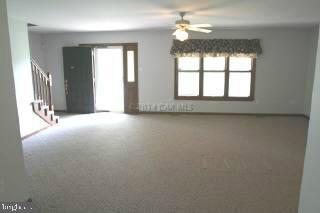 6536 Libertytown Road Berlin, MD 21811 - Photo 3 of 11 an empty room with windows and chandelier fan