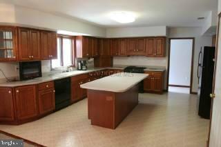 6536 Libertytown Road Berlin, MD 21811 - Photo 5 of 11 a kitchen with a stove top oven a sink a refrigerator and cabinets