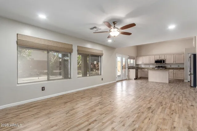 a view of an empty room with window and wooden floor