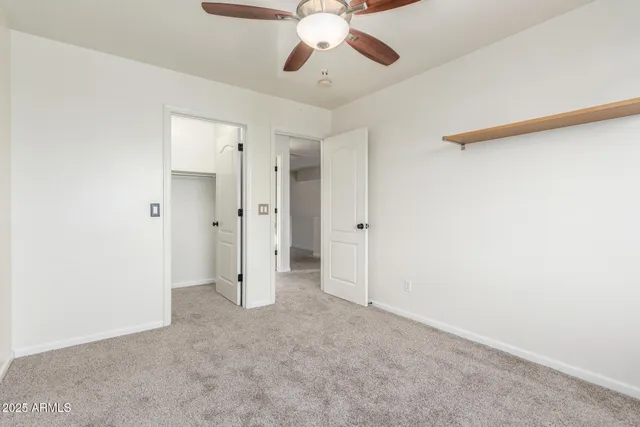 an empty room with fan and entrance