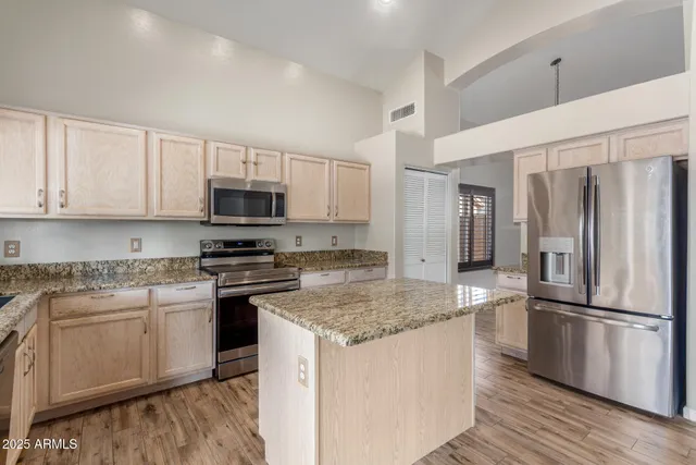 a kitchen with stainless steel appliances granite countertop a refrigerator stove microwave and sink