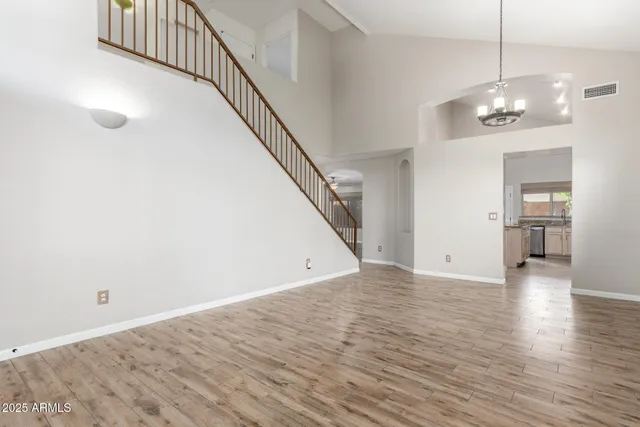 a view of a livingroom with wooden floor and stairs