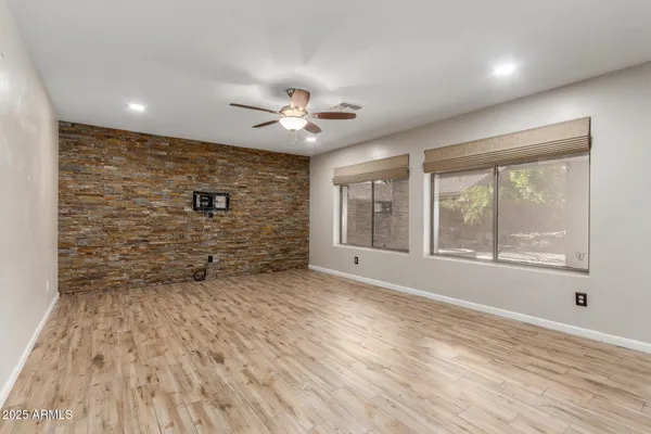 a view of an empty room with a window and a kitchen