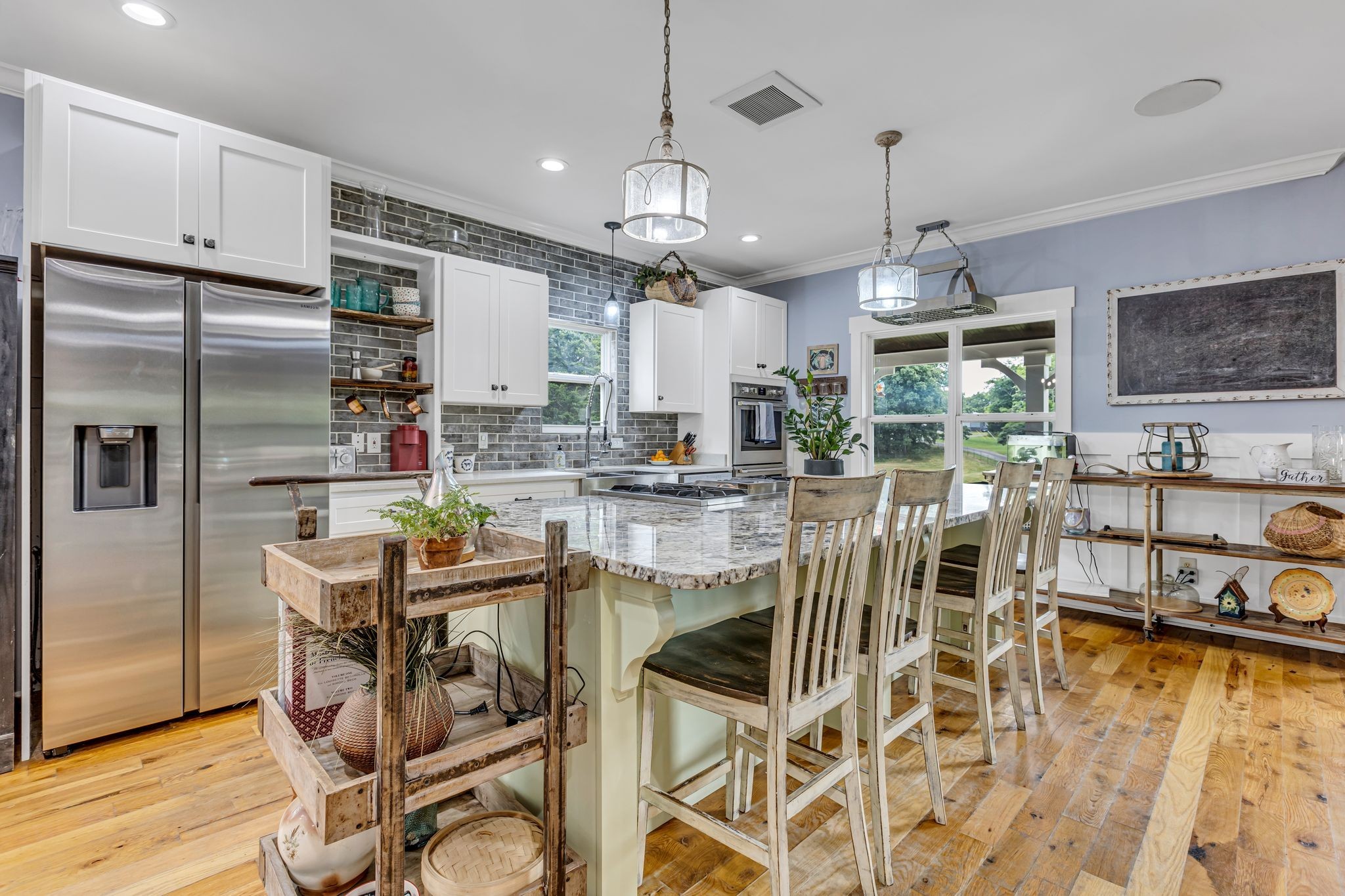 6770 Bly-Trice Road College Grove, TN 37046 - Photo 12 of 58 a kitchen with stainless steel appliances kitchen island granite countertop a dining table chairs and granite counter tops