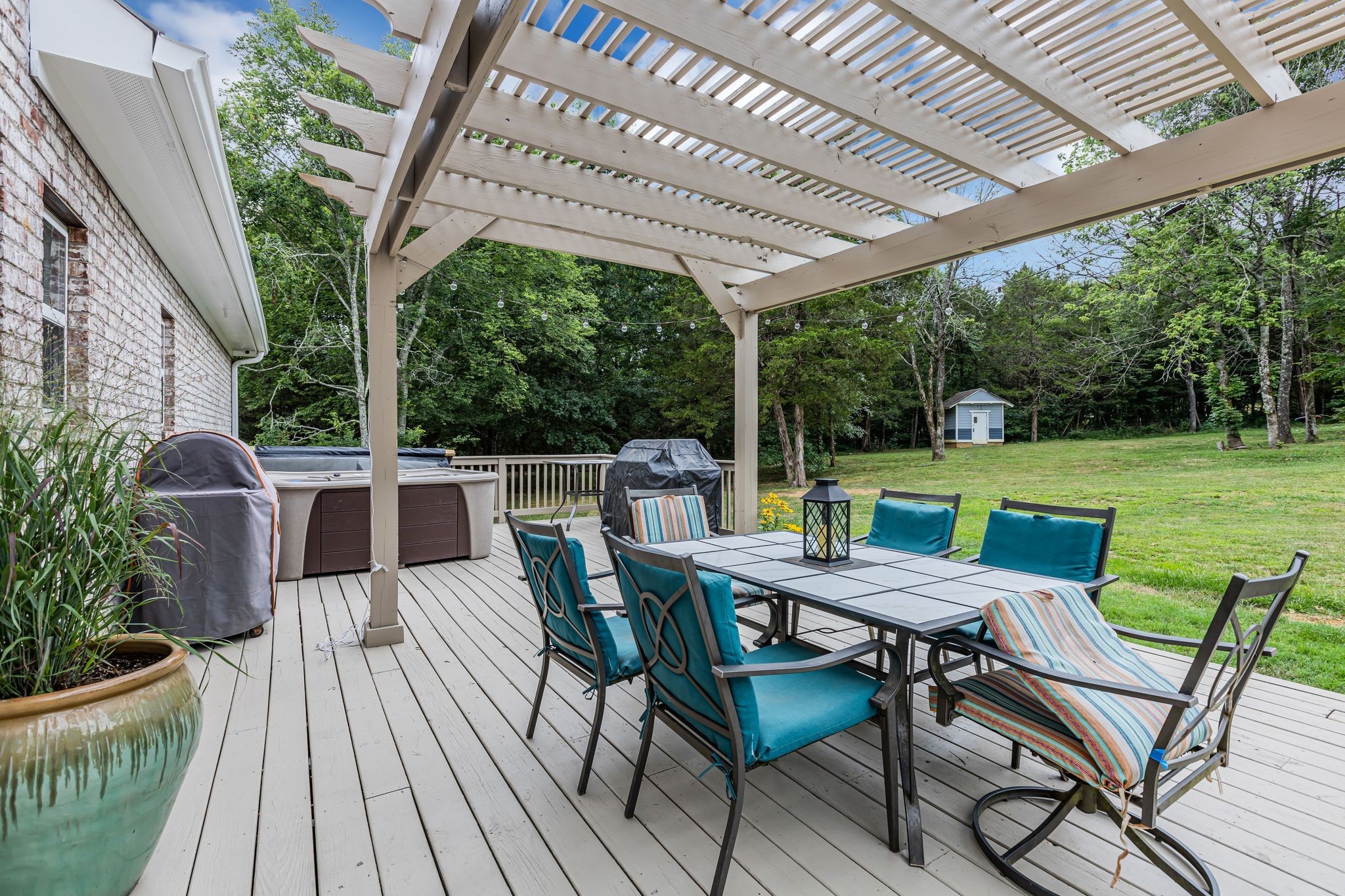 6770 Bly-Trice Road College Grove, TN 37046 - Photo 21 of 58 a patio table and chairs with potted plants and large tree