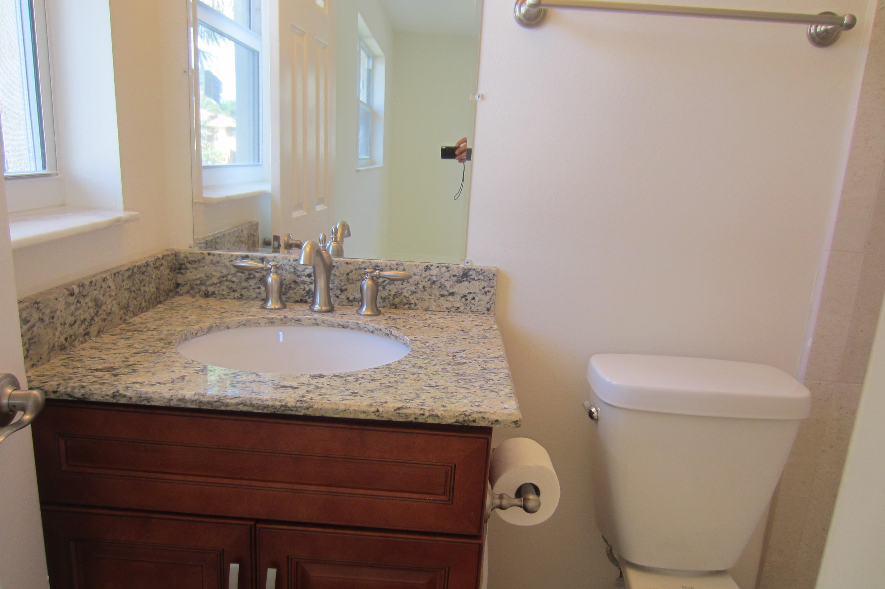310 Northeast 23rd Way Boca Raton, FL 33431 - Photo 5 of 16 a bathroom with a granite countertop toilet sink and mirror
