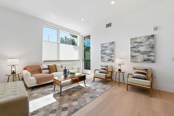 a living room with furniture a rug and kitchen view