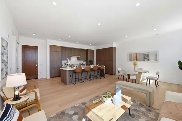 a view of kitchen island with stainless steel appliances granite countertop a couch and a living room view