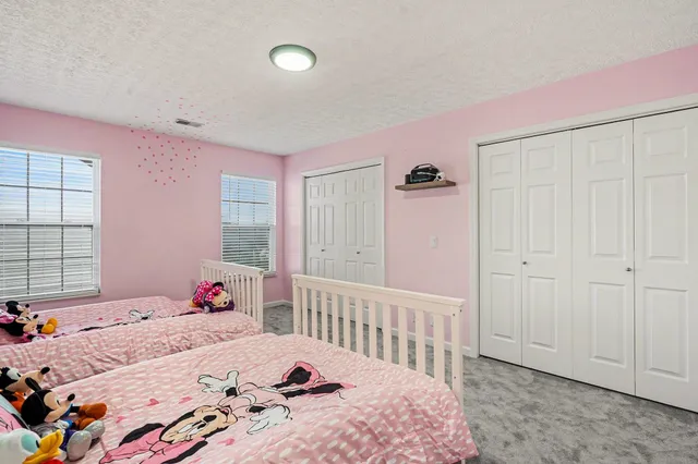 a bedroom with three beds and a baby crib