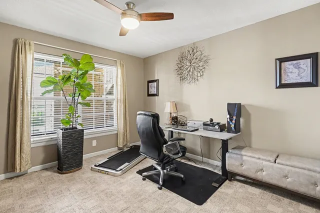 a view of a workspace with furniture and a window
