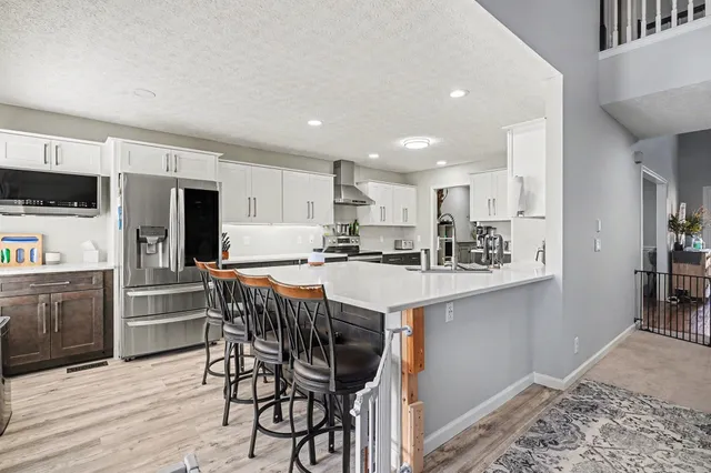 a kitchen with refrigerator a stove a sink and cabinets