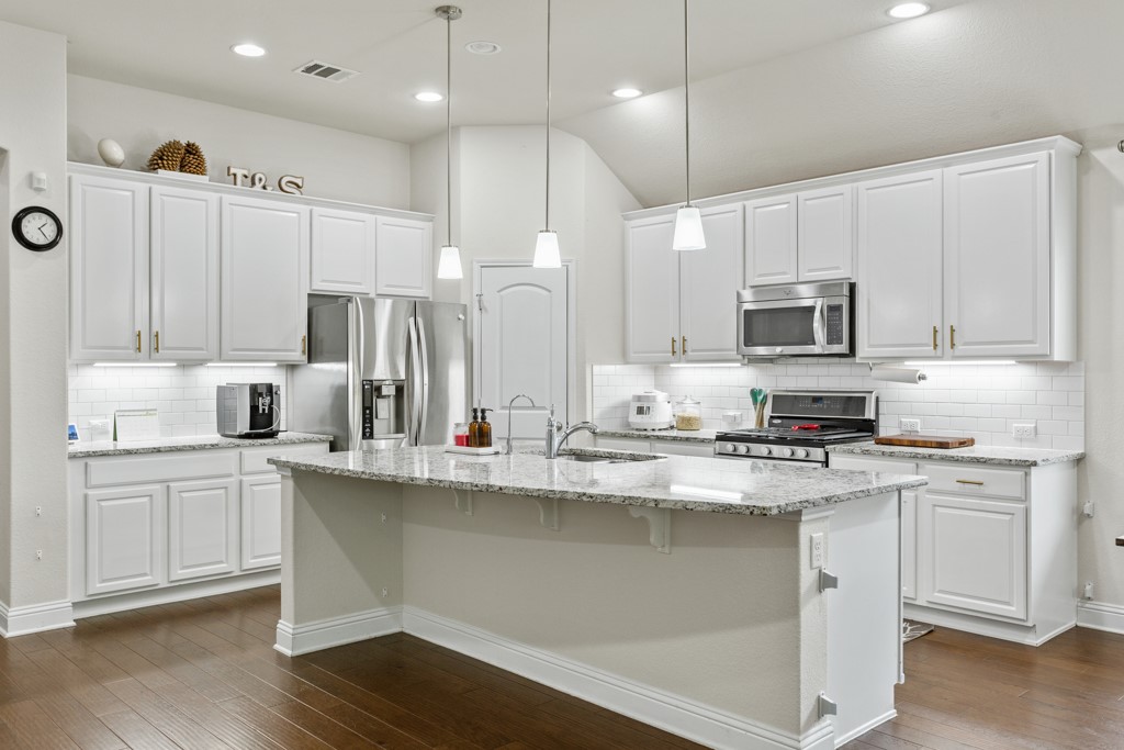 1916 Elaina Loop Leander, TX 78641 - Photo 9 of 23 a kitchen with stainless steel appliances granite countertop a sink a stove and cabinets