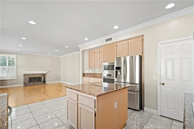 a kitchen with granite countertop a refrigerator sink and cabinets