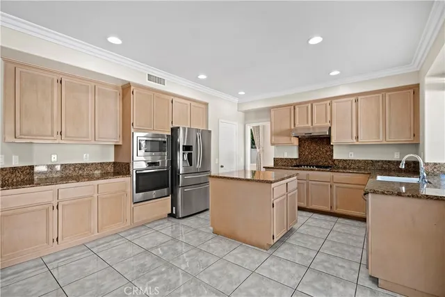 a kitchen with stainless steel appliances granite countertop a refrigerator and a stove top oven
